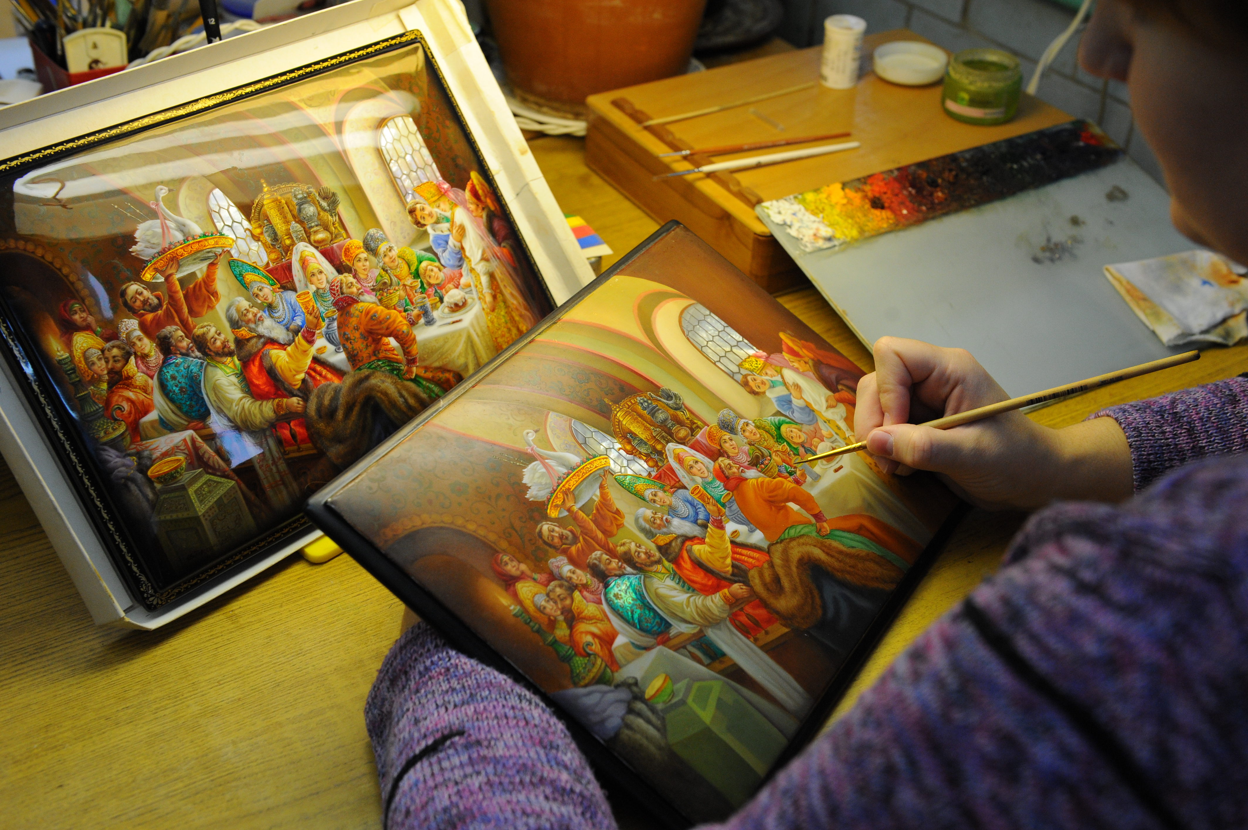 Художник расписывает шкатулку на Федоскинской фабрике миниатюрной живописи.